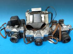 A collection of cameras to include a Polaroid 103 together with two Zenit-E and a Zenit- B cameras