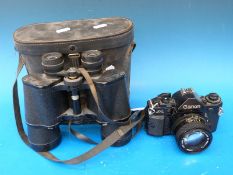 A Canon A1 camera and a cased pair of binoculars