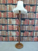 A Malaysian standard lamp with carved scene with buildings, palm trees etc,