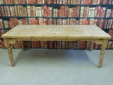 A solid pine kitchen table raised on turned legs