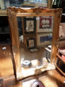A large wall mirror in ornate gilt frame (66cm high x 92cm wide)
