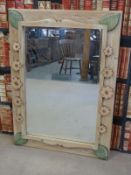 A large mirror with pine frame decorated with flowers and leaves