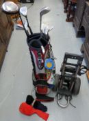 A collection of golf clubs to include a set of 'Wilson' irons in bag with trolley and accessories