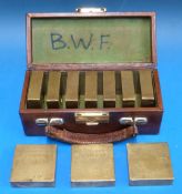 A leather case containing ten W&T Avery 1lb test weights