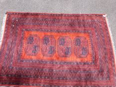 An Turkoman rug on wine red and orange ground with four central guls (196 x 131cm)