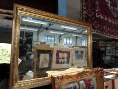 Two framed wall mirrors, one with bevelled glass, both in gilt stucco style frames,