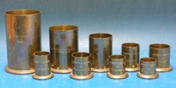A run of nine brass liquid measures (one pint down to one-sixth of a gill) each marked County