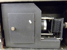A large cased electric magic lantern by Triumph with adjustable lens,