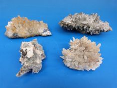 Four geological samples, all formed of narrow crystals,