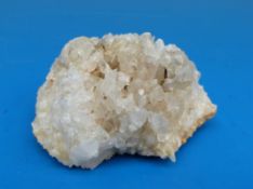 A geological sample formed of white crystals on an amber/brown coloured base,