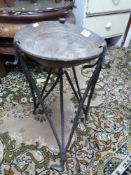 A carved wooden bowl on wrought iron stand,