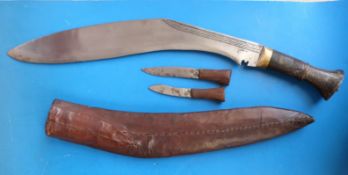 An edged kukri in tooled leather sheath