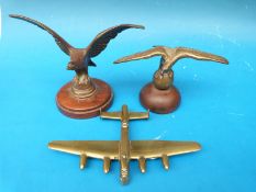 Two eagle car mascots together with a brass model of a Lancaster bomber