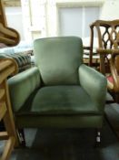 An upholstered armchair raised on tapering legs terminating in brass castors