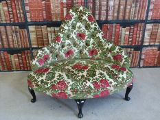 An upholstered corner chair raised on cabriole legs