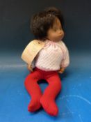 A 1960s Sasha baby doll with painted features, short black hair and jointed limbs,