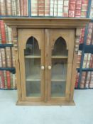 A pine glazed two-door wall cabinet and one other