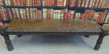 An oak coffee table with ornately carved border and lion masks to each corner,