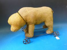 An early 20thC Steiff push-a-long bear standing on all fours,