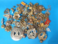 A tin containing a selection of militaria, badges,