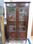 A late 19thC glazed mahogany bookcase with brass decoration and bevelled glass with retailer's mark