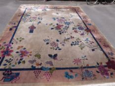 An early 20thC large Chinese rug decorated with urns,
