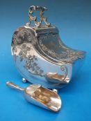 An embossed and engraved sugar box formed as a coal box,