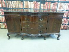 A carved serpentine fronted mahogany sideboard raised on ball and claw feet (W182 x D68 x H98cm)