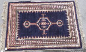 A handmade rug with three central diamond guls,