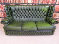 A green leather Chesterfield button-backed three-seater sofa