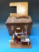 A cased toy sewing machine mounted on metal frame