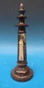 A serpentine lighthouse thermometer with red flecks to body