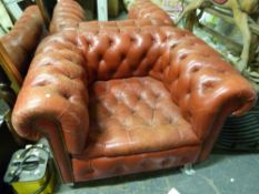 A pair of red leather Chesterfield armchairs