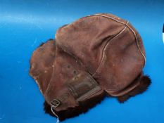 A Royal Flying Corps leather helmet with fur lined trim and fold back ear flaps.