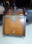An Art Nouveau brass and mahogany coal scuttle