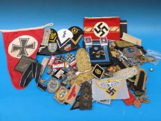 A collection of Nazi German militaria, badges, fabric patches,