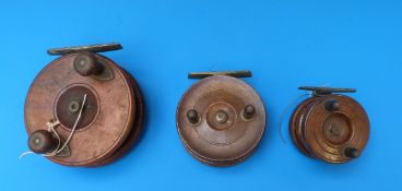 Three vintage wooden and brass fishing reels, the largest 4.