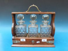 A three bottle oak tantalus with key and silver plated fittings.