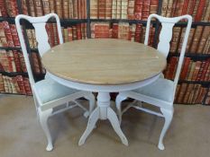 A circular painted beech table and two chairs
