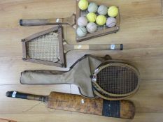 A group of vintage tennis racquets and a cricket bat