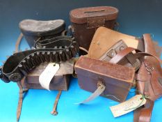 A collection of 11 holsters, belts and other leather gun accessories.