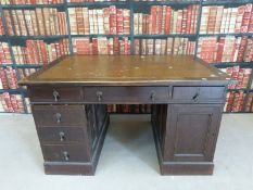 A leather inset twin pedestal oak desk (W137 x D91 x L78)