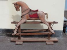 A vintage wooden rocking horse with leather harness,