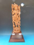 A large Indonesian carved wooden figurine of a goddess on a rosewood base