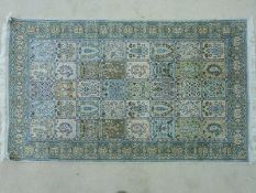 A Persian silk carpet with decorated panels (160 x 90cm)