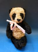 A vintage panda bear with jointed limbs probably Merrythought or Chiltern Hygienic Toys, 36cm tall.