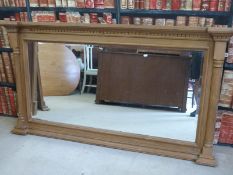 A large pine wall mirror with half-column decoration, dentil moulding and bevelled glass,