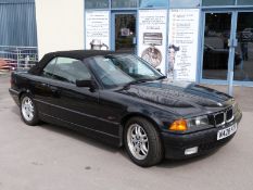 A 1995 BMW 328i convertible, black, with keys,