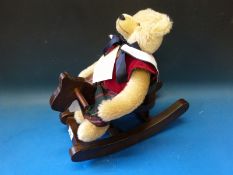A Hermann mohair bear sitting on a wooden rocking horse