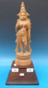 A Indonesian carved wooden figurine of a goddess on a rosewood base